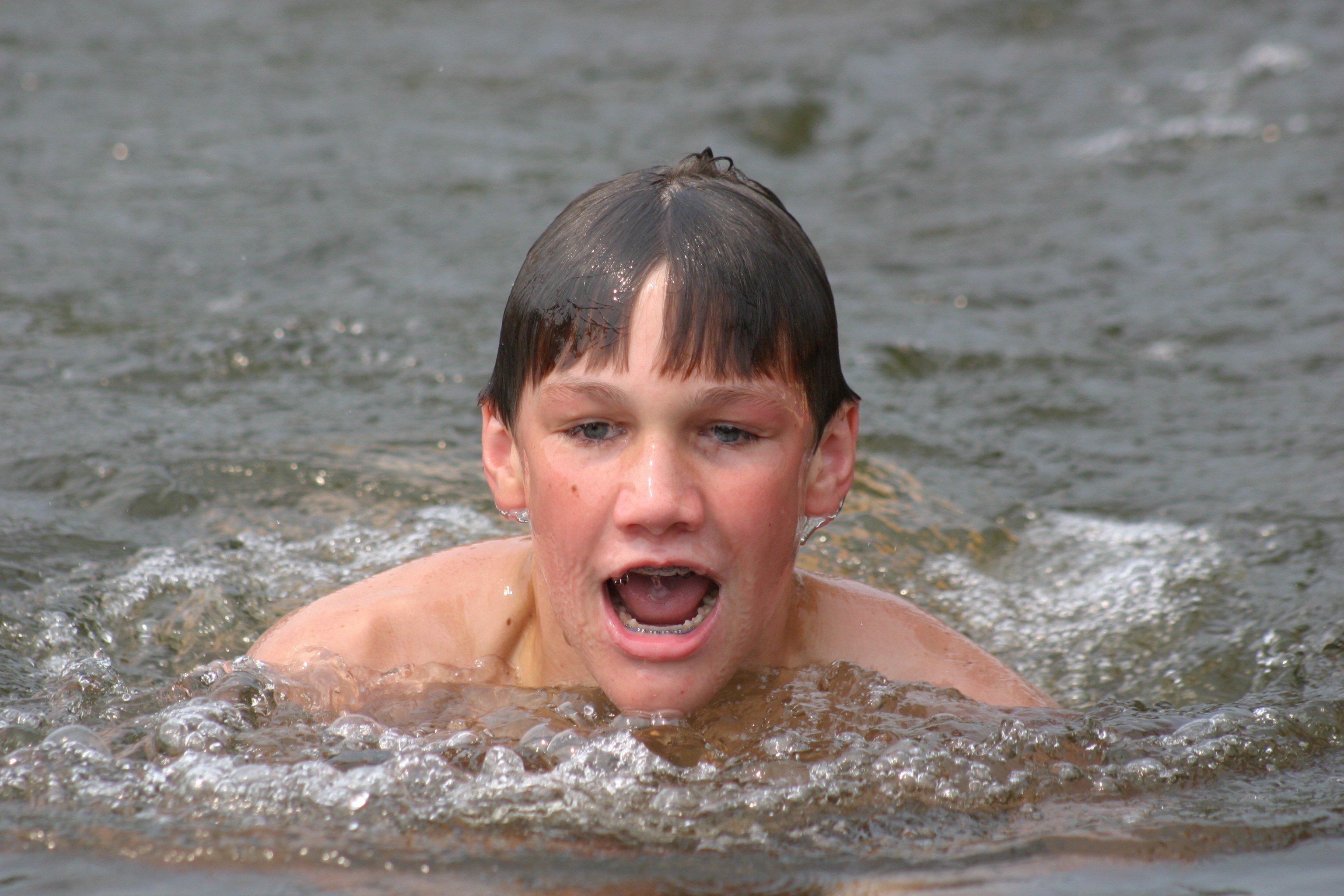 Boy taking a breath while swimming breaststroke