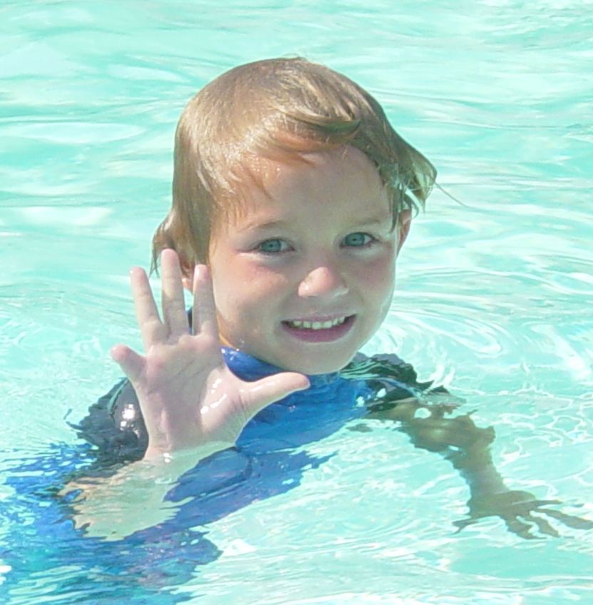 Young Boy waving from swimming pool